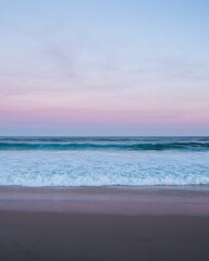 Obraz premium Aerial view of ocean waves, boats and sunset