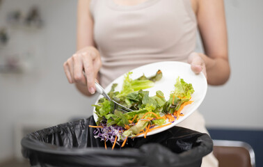 A person is throwing food into a trash can, separating waste and food for decomposition. Environmental care concept.