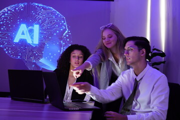 multinational team of one man and two women gathered to brainstorm and discuss their work together. They used computers to present a stock market report using AI charts.