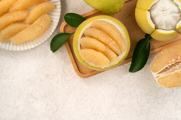 Fresh pomelo fruit with leaf on white table background.
