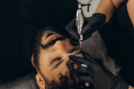 Man receiving permanent eyebrow makeup procedure
