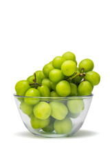 Close up of fresh green grapes with water drops on glass bowl isolated on white background