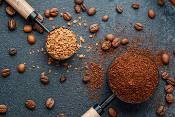 Coffee beans in measuring scoop on dark background