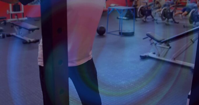 Man positioning barbell on shoulders in gym squat rack and repeating controlled squats for strength