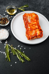 Marinated pork ribs on white plate with herbs and spices