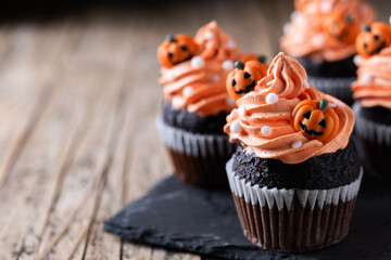 Halloween cupcakes with Halloween sprinkles on wooden table. Copy space