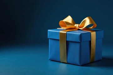 Obraz premium Sophisticated blue gift box with golden bow, copy space Dark blue backdrop , festive, occasion