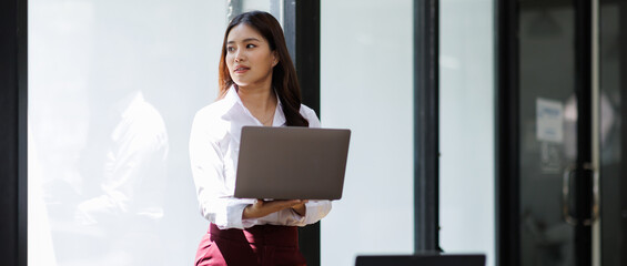 Attractive business finance asian woman, Manager with laptop in the office area of coworking space
