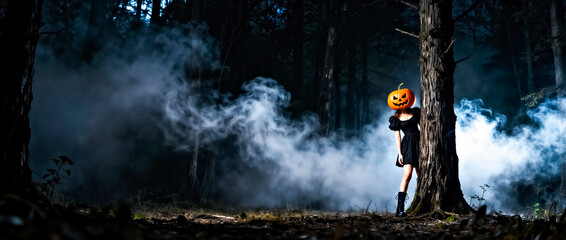 Dark Forest with Smoke with Stylish Woman Wearing Pumpkin on Head Peeking out from Behind Tree in Distance 