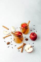 Warm apple drinks with cinnamon sticks, star anise, cloves, and fresh apples © reddish