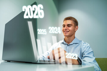 Young man working on a laptop while forecasting future trends in a modern office setting