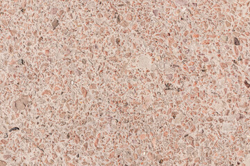 Beautiful beige background of natural building material. Beige building mixture with fragments of natural stone. Layout of the building covering