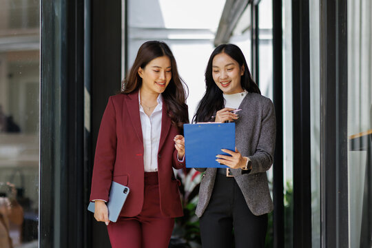Two Asian business people walking street at business office center.Young business corporate team meeting in a business park.Leadership,coaching and group of people Discuss meeting
