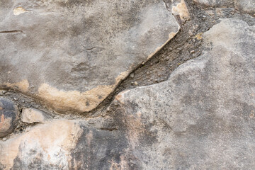 Abstract background of the rocky surface of natural grey stone with different shades of natural stone. rough texture cracks. Realistic photo