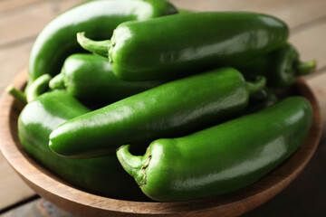 Fresh jalapeno peppers in bowl on table, closeup