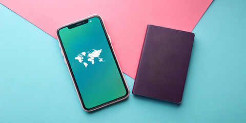 A mobile device shows a world map on its screen. Next to it lies a purple notebook, both placed on a vibrant blue and pink background. This setup reflects a travel or planning theme