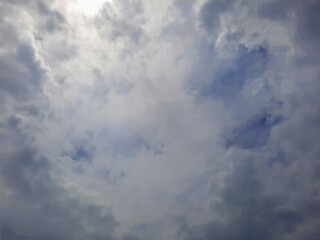 Sunlight peeking through thick clouds, creating a mystical and moody cloudy sky, dramatic weather in the sky