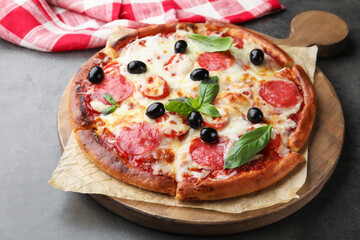 Delicious pizza with cheese, salami, olives and basil on grey table, closeup