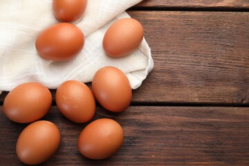 Raw chicken eggs on wooden table, flat lay. Space for text