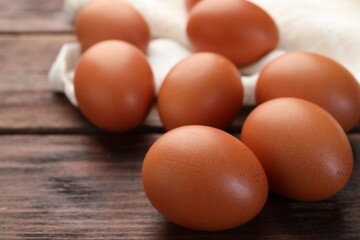 Raw chicken eggs on wooden table, closeup. Space for text