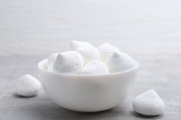 Yummy meringue cookies in bowl on grey table, closeup