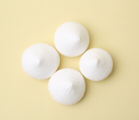 Yummy meringue cookies on beige background, flat lay