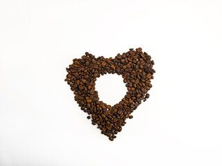 Heart shape made of roasted coffee beans on white background