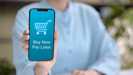 Buy Now Pay Later on mobile app, hand holding smartphone with shopping cart icon, BNPL fintech payment