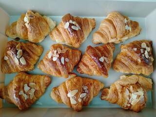 Golden delicious honey almond croissants arranged perfectly offer delightful sweet treat. Baked with flaky pastry, these tempting breakfast items create truly indulgent bakery experience