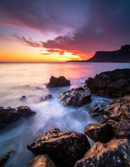 Dramatic sunset over ocean rocks