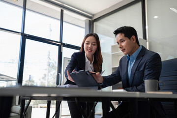 Business team analyzing documents, graphs, and data with a laptop, tablet, and smartphone. Collaboration, strategy, and success