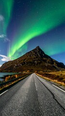 Mountain road under vibrant aurora borealis