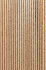 Brown corrugated cardboard texture background with vertical pattern. Abstract paper surface perfect for packing, shipping, or as craft material for various projects