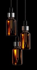 Amber glass dropper bottles hang, illuminated, against black