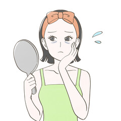 目のクマが気になり鏡を見る女性