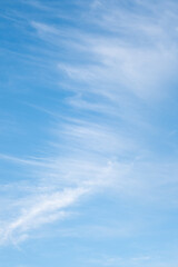 Blue sky with graceful white clouds. Diagonal cloud background.