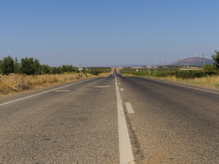 Road leading straight along flat terrain in the countryside