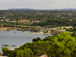 Bridge over the bay of a lake, boats anchored in the bay