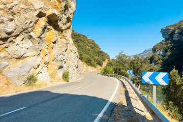 Scenic winding road by the Sobron reservoir in Burgos, Spain. A picturesque mountain road with curves surrounded by nature, green hills, and peaceful waters. High quality photo