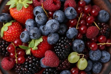 Obraz premium Different ripe berries in bowl, top view