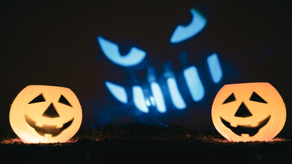 Twin jack-o'-lanterns with evil smiling face projected