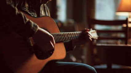 Fototapeta premium Acoustic guitar perfomance with close focus on hand and wood grain