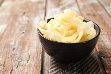Dried shredded squid in bowl on color wooden table, closeup. Space for text