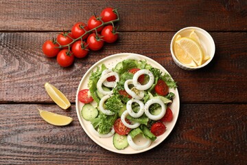 Delicious salad with squid rings, vegetables and spices served on wooden table, flat lay