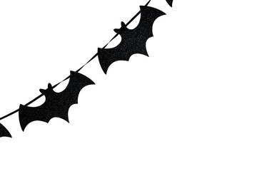 Halloween paper garland with black bats on white wall. Seasonal decoration background for autumn holidays, parties, advertising, ecommerce banners.