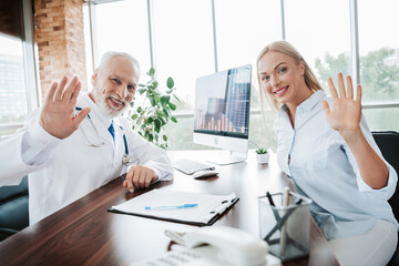 Friendly doctor and a female patient smiling warmly during a medical consultation in a modern...