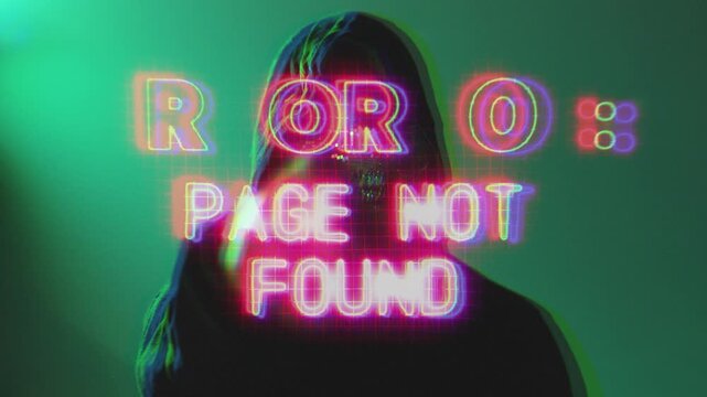 Anonymous hacker in a dark room wearing hoodie and mask typing on laptop with glowing error 404 warning screen. Strong concept for cybercrime and online fraud visuals.