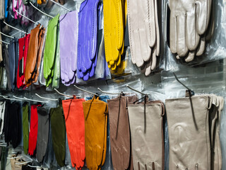 Colorful display of gloves hanging in a store showing a variety of styles and colors in an indoor shopping environment