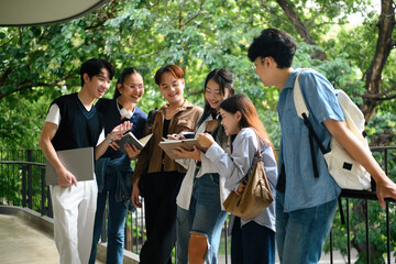 A group of young university students happily chatting and sharing ideas, participating in an outdoor group study
