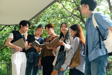 Obraz premium A group of university students gathered outside, reading books and discussing assignments with teamwork and focus